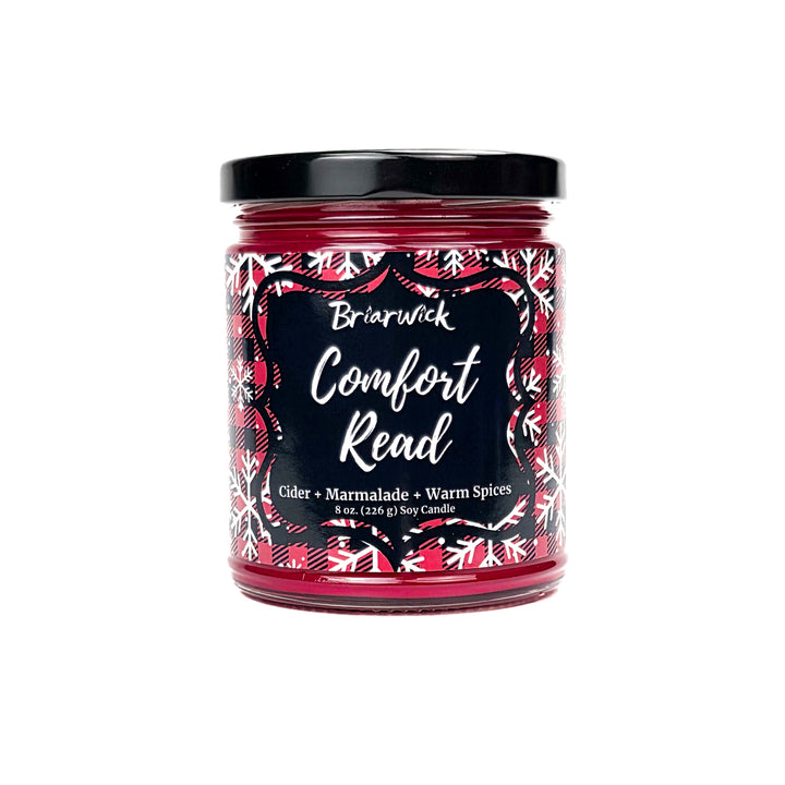 Comfort Read 8oz colored candle with red flannel and white snowflake design on a white background