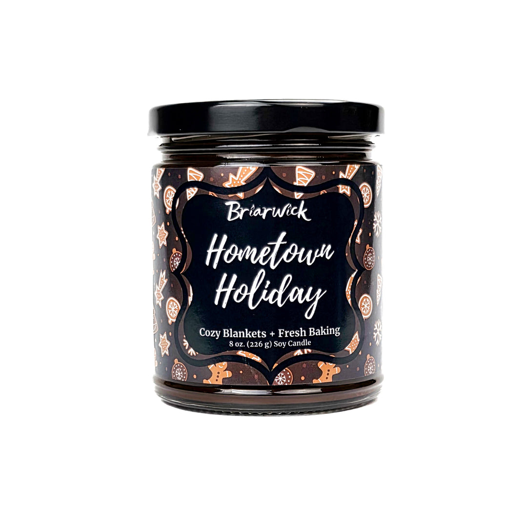 Hometown Holiday 8oz colored candle with brown and white decorated gingerbread  design on a white background