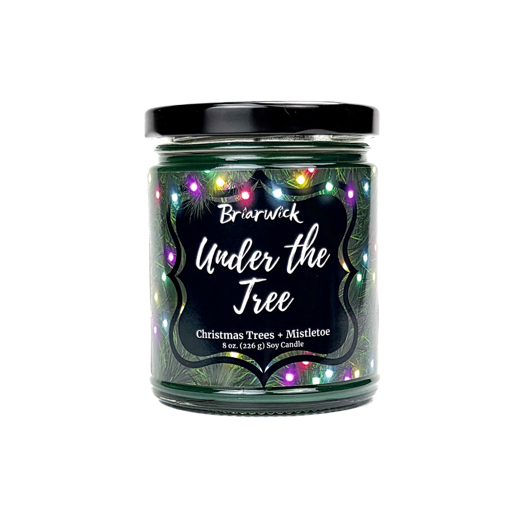 Under the Tree 8oz colored candle with christmas tree and colorful lights design on a white background