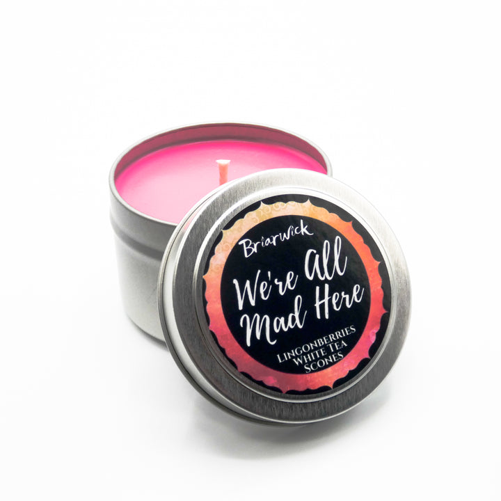 a small tin with a pink candle inside of it