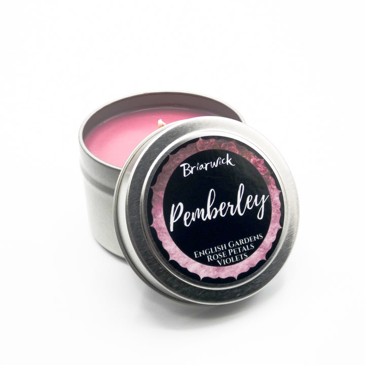 a tin of pink candle sitting on top of a white table