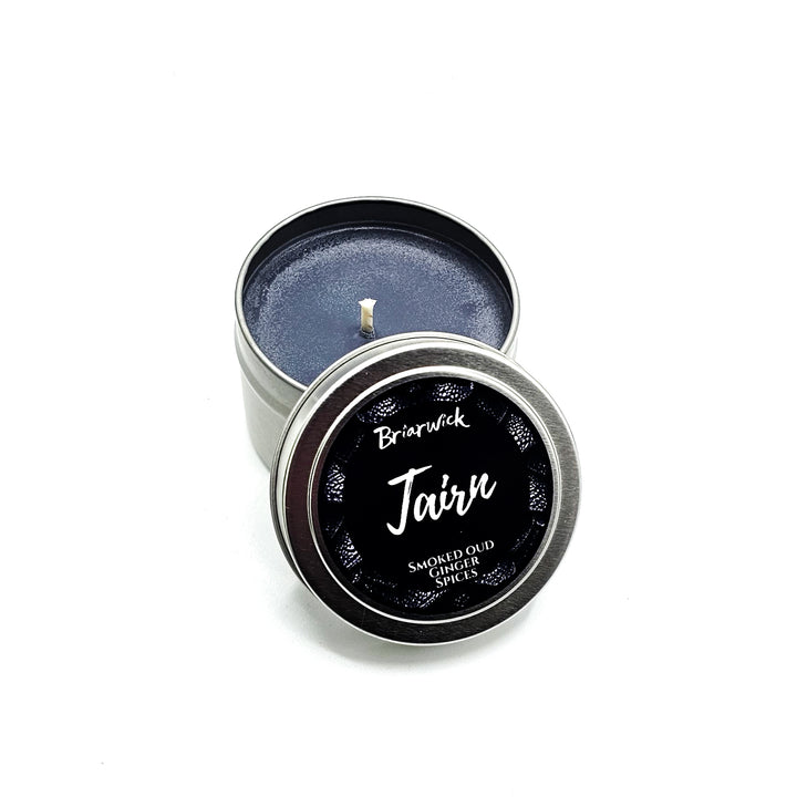 a tin with a black lid sitting on a white surface