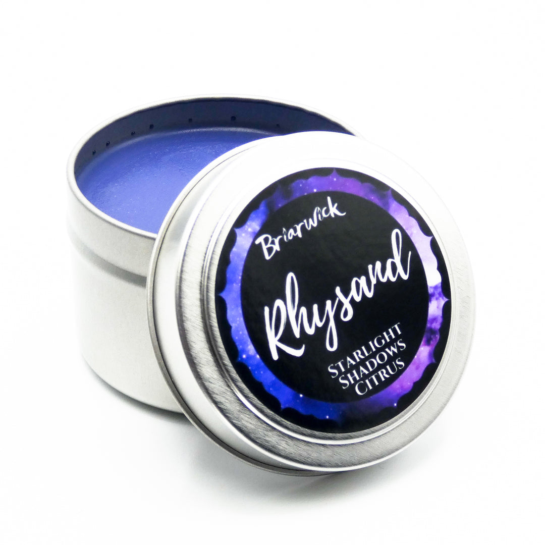 a tin of blue and purple colored wax on a white background