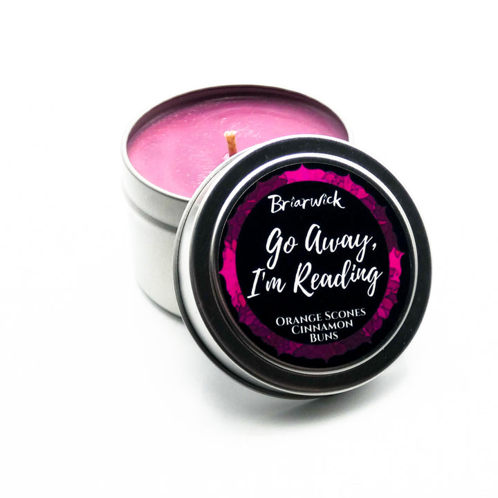 a small tin with a pink candle inside of it