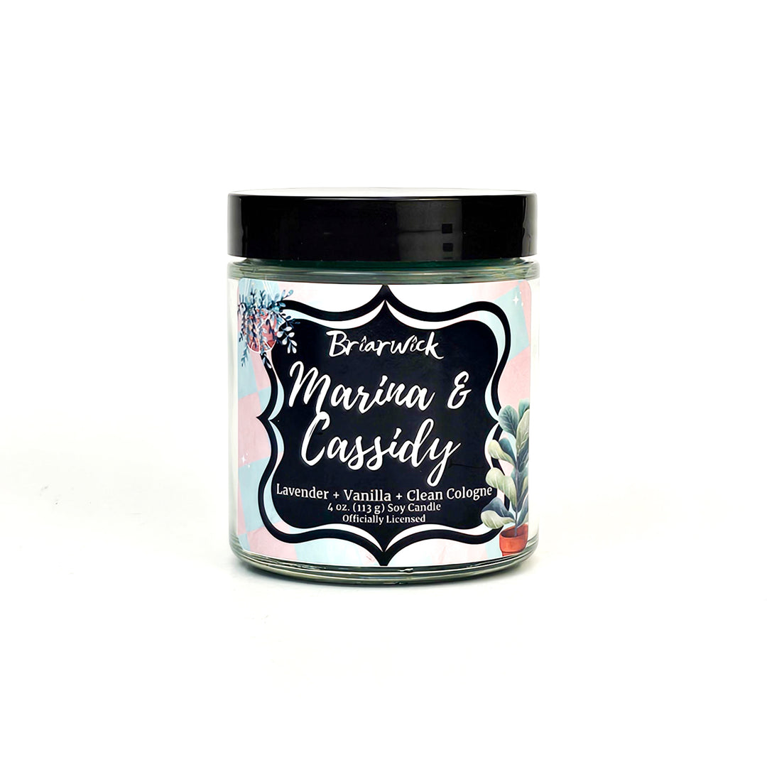 Marina & Cassidy 4oz blue green candle with pink/blue checker design on a white background
