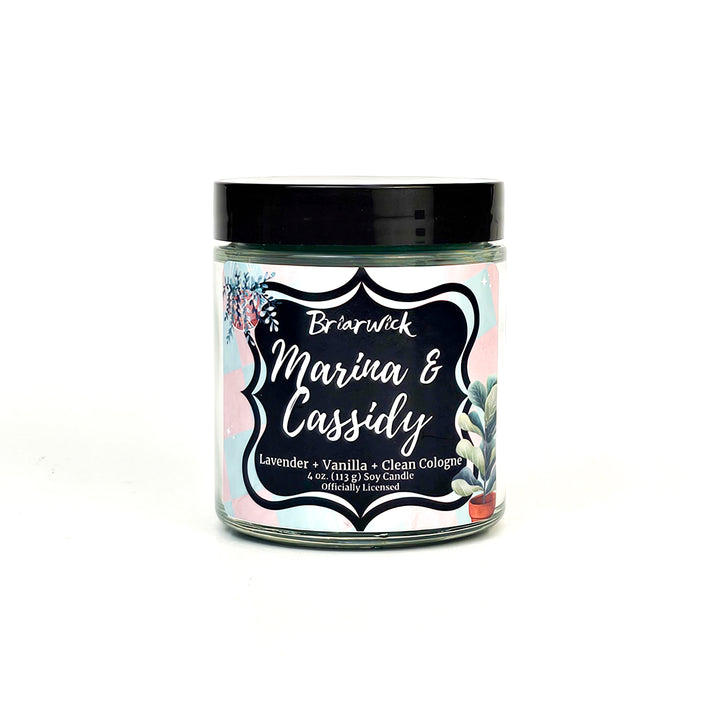 Marina & Cassidy 4oz blue green candle with pink/blue checker design on a white background