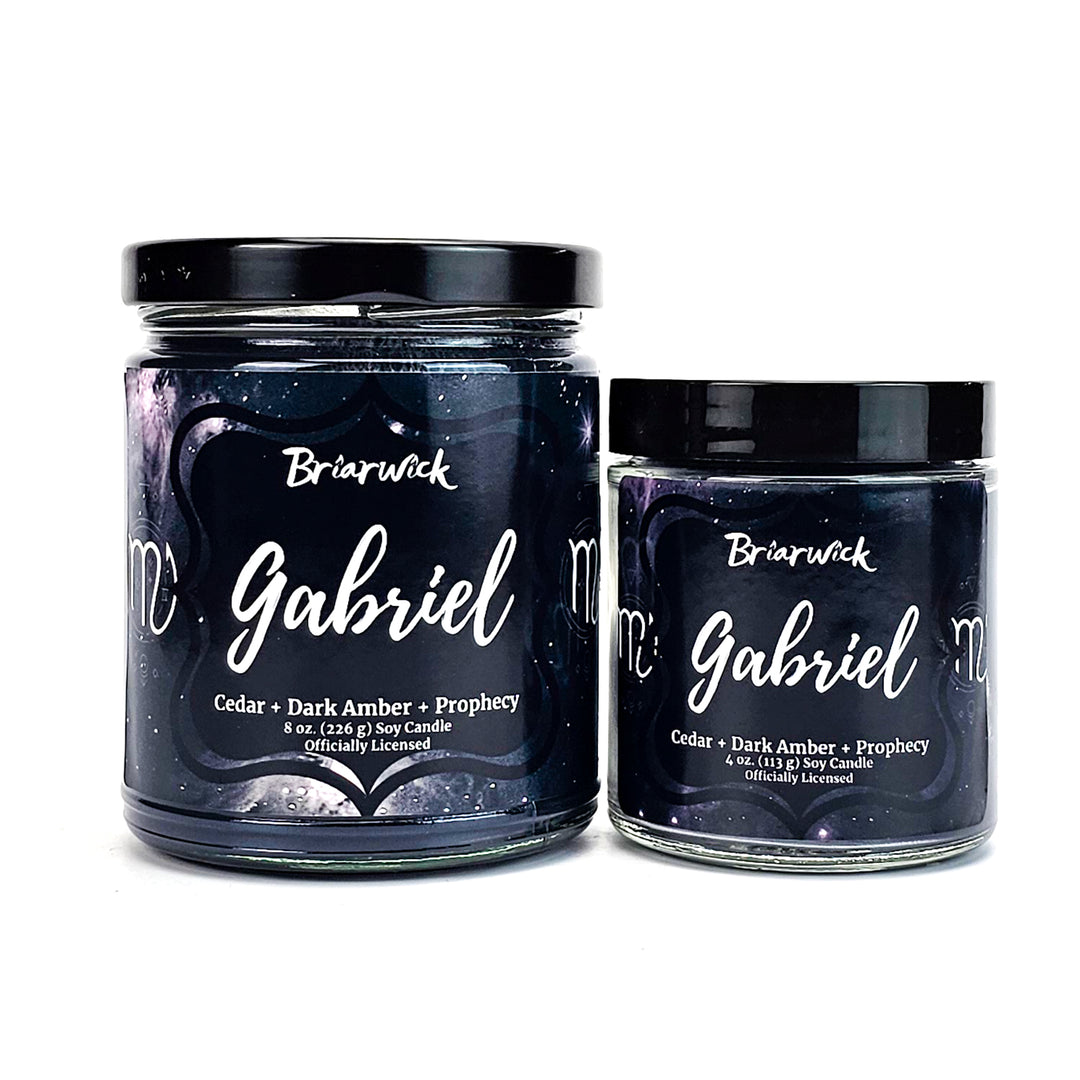 two jars of gourmet candles sitting next to each other