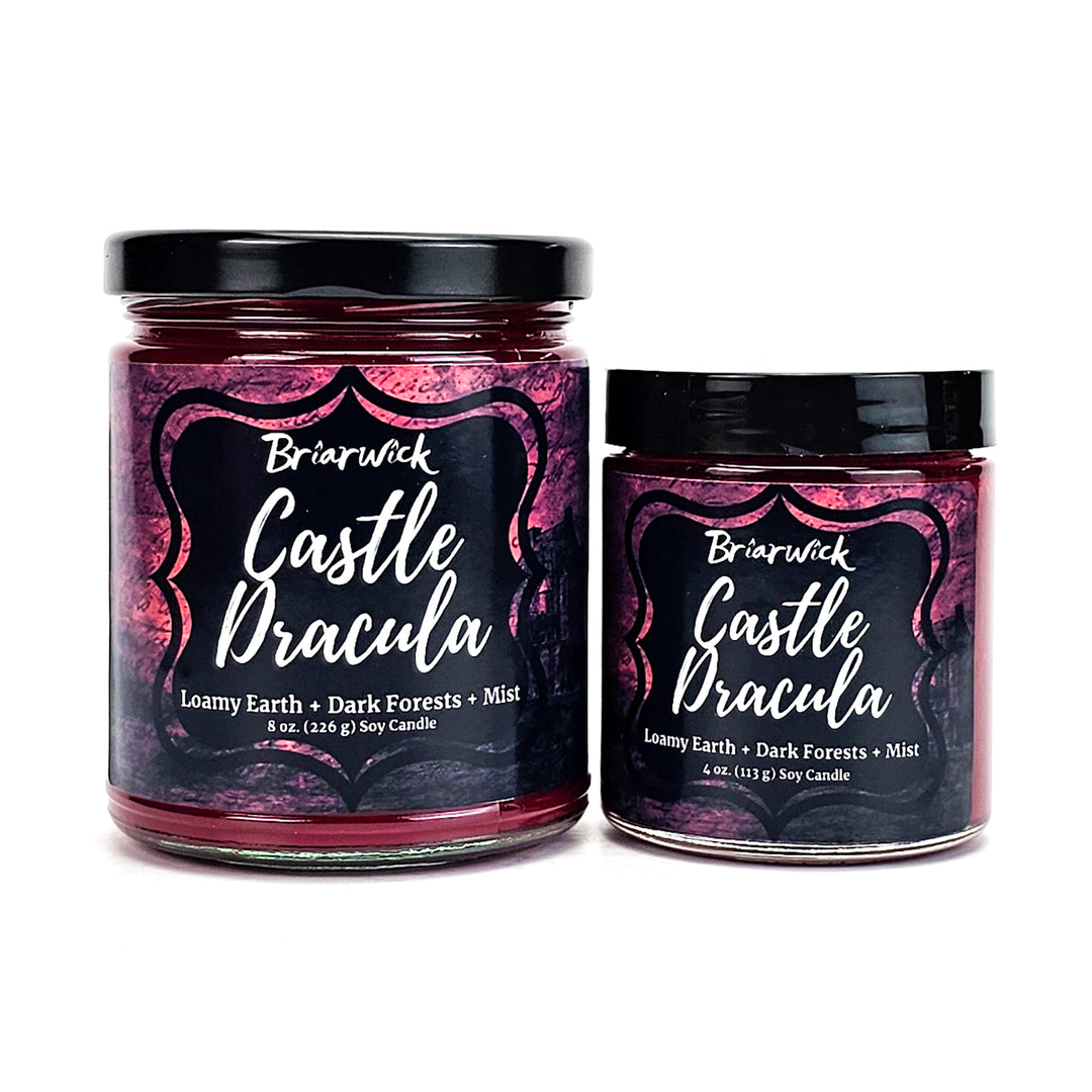 Castle Dracula 8oz & 4oz garnet candles with red parchment designs on a white background