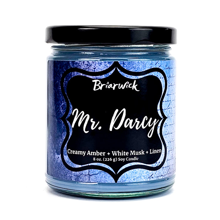 Mr. Darcy 8oz steel blue candle with blue parchment design on a white background