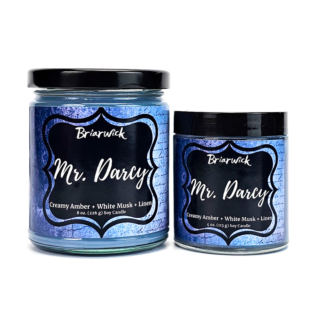 Mr. Darcy 8oz & 4oz steel blue candles with blue parchment designs on a white background