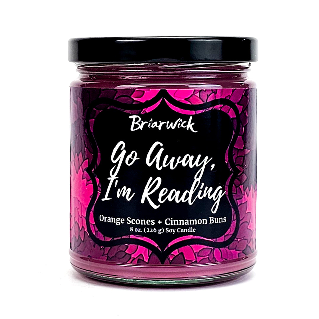 Go Away, I’m Reading 8oz magenta candle with magenta floral design on a white background