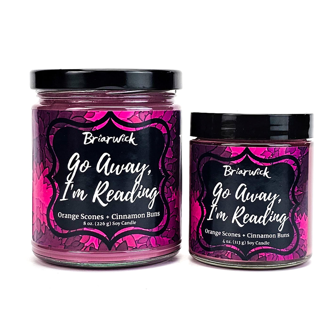 Go Away, I’m Reading 8oz & 4oz magenta candles with magenta floral designs on a white background