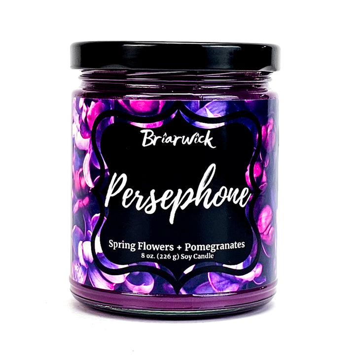 Persephone 8oz crocus purple candle with a purple flower design on a white background