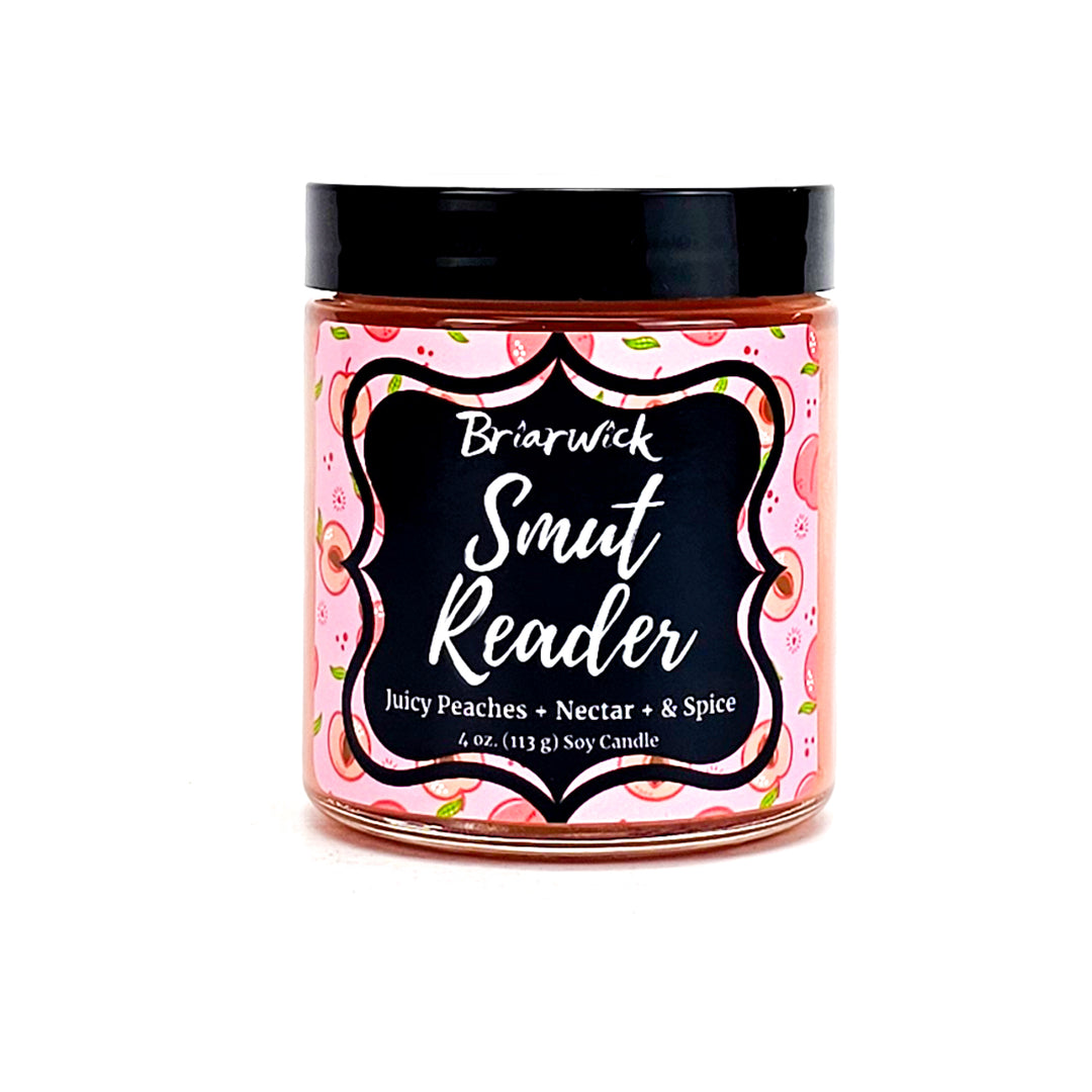 Smut Reader 4oz dark peach candle with pink peach design on a white background