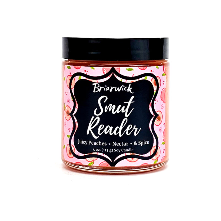 Smut Reader 4oz dark peach candle with pink peach design on a white background